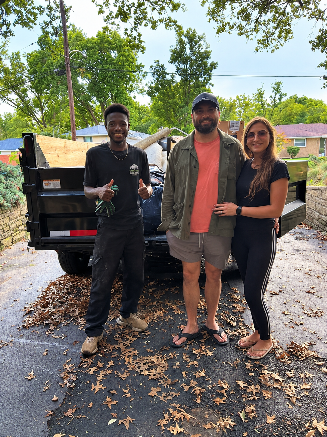 Paul's Junk Removal and Demo team smiling and giving thumbs up beside their truck
